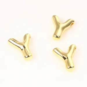 Detailed view of polished gold-plated copper Y-letter charms for jewelry crafts