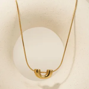 Collana minimalista in acciaio inossidabile dorato con un pendente geometrico a U lucido