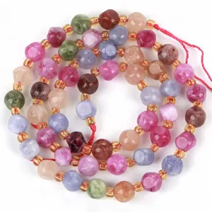 Primo piano di perle in tormalina naturale sfaccettata multicolore per creazione gioielli