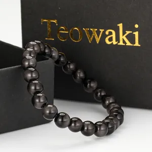 Detailed close-up of a cat eye imitation tiger eye beaded bracelet on black gift box