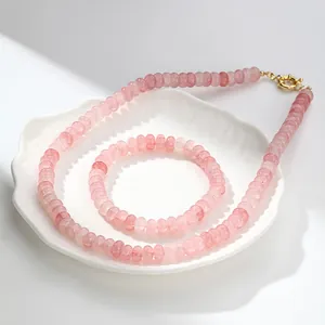 Vista detallada de un conjunto de collar y pulsera de cuentas de cristal rosa natural en plato
