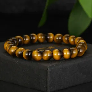 Macro detail of polished faux tiger eye glass beads on an elegant black jewelry display box