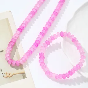 Detalle del conjunto de collar y pulsera de cuentas de cristal rosa craquelado en blanco
