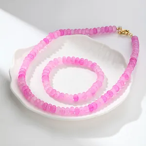 Detalle de conjunto de collar y pulsera de cuarzo rosa craquelado sobre un plato decorativo.