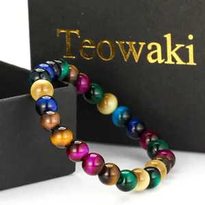 Macro detail of vibrant multicolored imitation tiger eye glass beads on a black gift box