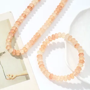 Detalle del conjunto de collar y pulsera de cristal natural color melocotón brillante