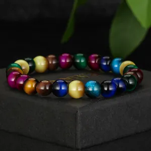 Close-up detail of a multi-colored cat's eye glass beaded bracelet on a black gift box