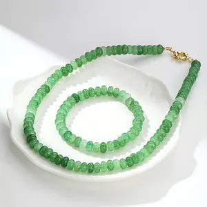 Detalle de un conjunto de collar y pulsera de cristal crackle verde sobre un plato blanco