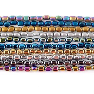 Dettaglio file di perle di ematite ovali multicolore con texture opache e metalliche