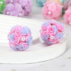 Macro detail of handmade pink and purple clay rose flower ball beads with pearl accents