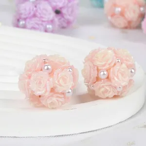 Macro view of delicate pink resin rose flower balls with white pearls and glitter details