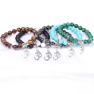Close-up detail of 6 natural stone beaded bracelets featuring silver-toned Om charms