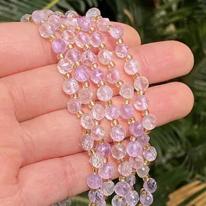 Vista detallada de cuentas de cristal facetadas moradas y rosas para suministros de joyería