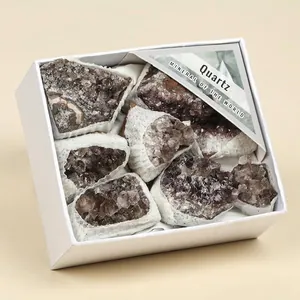 Close-up view of natural smoky quartz crystal clusters arranged in a white gift box.