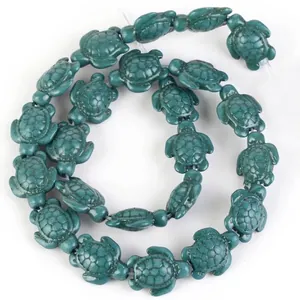 Macro detail of synthetic turquoise stone beads in sea turtle shape for DIY jewelry.