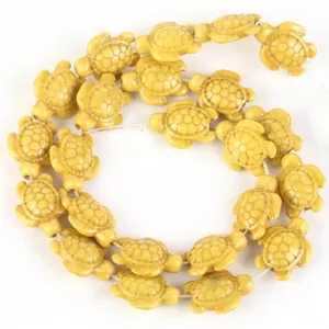 Detail view of yellow turtle-shaped synthetic turquoise beads for DIY jewelry making.