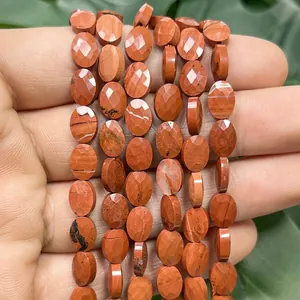 Macro detail of faceted 6x8mm red jasper flat oval beads for DIY jewelry making