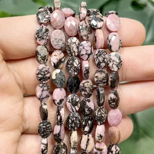 Detail view of 6x8mm faceted flat oval natural pink rhodonite stone beads for DIY jewelry