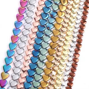 Close-up of colorful heart-shaped hematite beads showing various metallic finishes