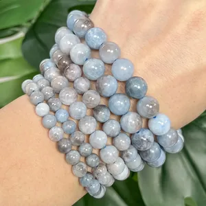 Close-up detail view of natural blue aquamarine stone beads on wrist for DIY jewelry making