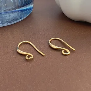 Gros plan de crochets d'oreilles en cuivre plaqué or 18k pour bijoux DIY.