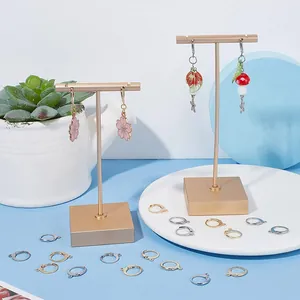 Dettaglio di ganci per orecchini a forma di D e accessori circolari su supporto dorato
