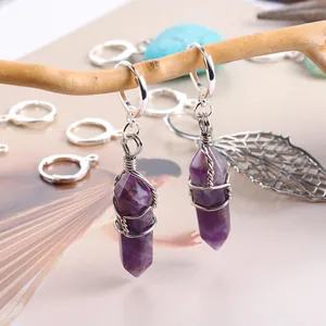 Gros plan de boucles d'oreilles artisanales en améthyste violette avec fil enroulé.
