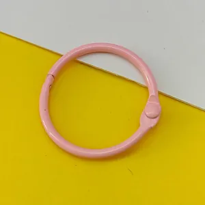 Macro detail of a 30mm pink metal loose-leaf binder ring for DIY keychain accessories.