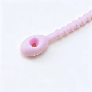 Close-up of pink silicone cable tie showing textured grip and head loop detail.
