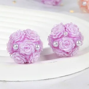 Detail of purple polymer clay rose beads with glitter and white pearls for DIY crafts.