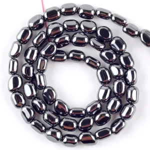 Vista macro di perle di ematite nera ovale lucida per accessori per la creazione di gioielli