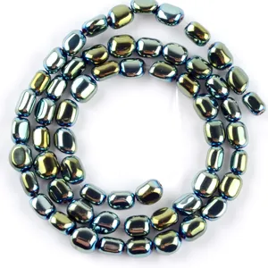 Primo piano di perle di ematite ovali iridescenti con lucentezza metallica per gioielli