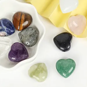 Close-up of heart-shaped natural stone beads with horizontal holes for DIY jewelry.