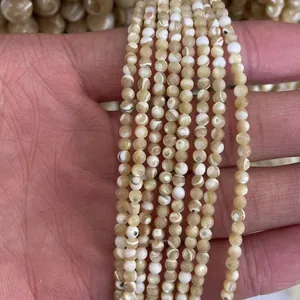 Cuentas de concha redondas naturales de 2mm 3mm para joyería mostradas en mano para escala