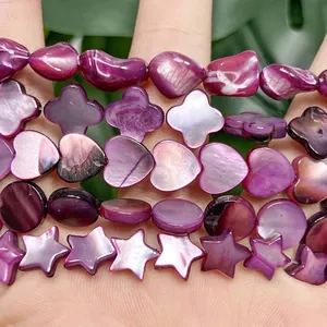 Dettaglio di varie forme di perle in conchiglia viola scuro per creazioni di gioielli