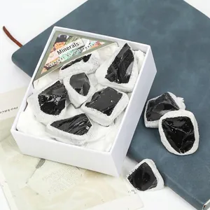 Piedras minerales de obsidiana negra natural en un conjunto de caja de regalo blanca mínima