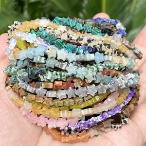 Detail view of colorful 6mm star-shaped natural stone beads held in a person's hand