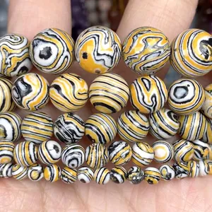 Close-up of yellow natural stone round beads with black and white swirl patterns
