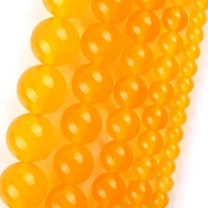 Detail shot of various sized yellow natural stone round beads for jewelry making