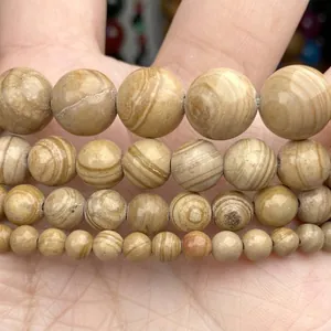 Close-up macro detail of yellow striped natural stone round beads for jewelry making