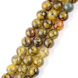Detailed macro view of yellow dragon vein agate round beads for jewelry making.