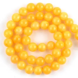 Close-up detail of polished yellow natural stone round beads for DIY jewelry making crafts