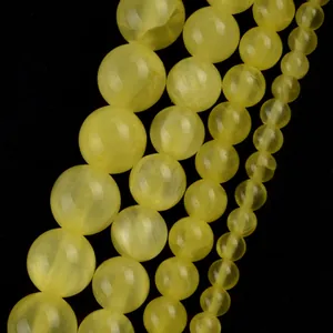 Close-up of natural yellow stone round beads in various sizes for jewelry making