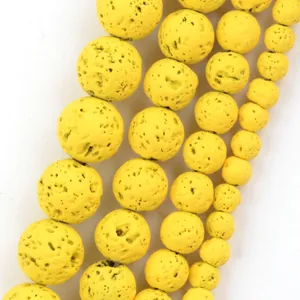 Macro detail of porous yellow volcanic lava stone round beads for DIY jewelry making