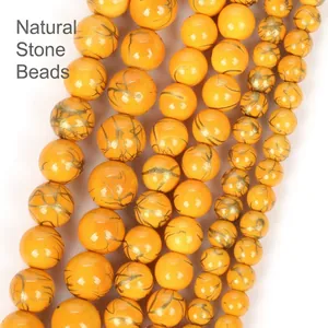 Macro view of yellow natural stone beads with golden crackle pattern for jewelry making