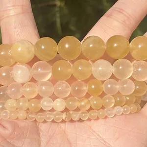 Macro view of translucent yellow natural stone round beads in multiple sizes for jewelry making