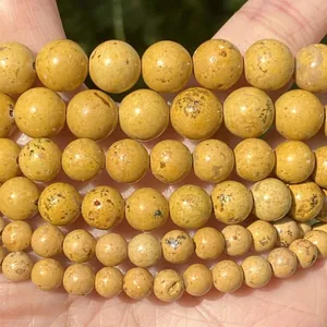 Macro detail of yellow natural stone round beads showing unique texture for DIY jewelry