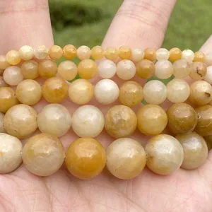 Macro detail of natural yellow stone round beads in various sizes for jewelry