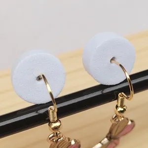 Macro view of white foam jewelry spacers for earring hook protection and packaging