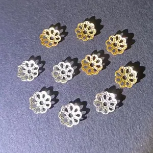 Détail macro de calottes de perles fleurs évidées dorées et argentées pour la création bijoux.